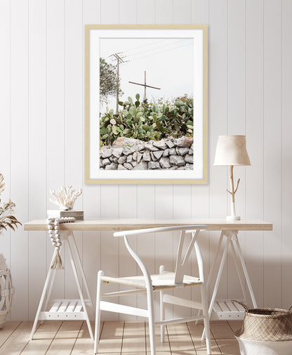 coastal decor featuring neutral, minimal print with cross and cactus. Photograph taken in Santorini Greece