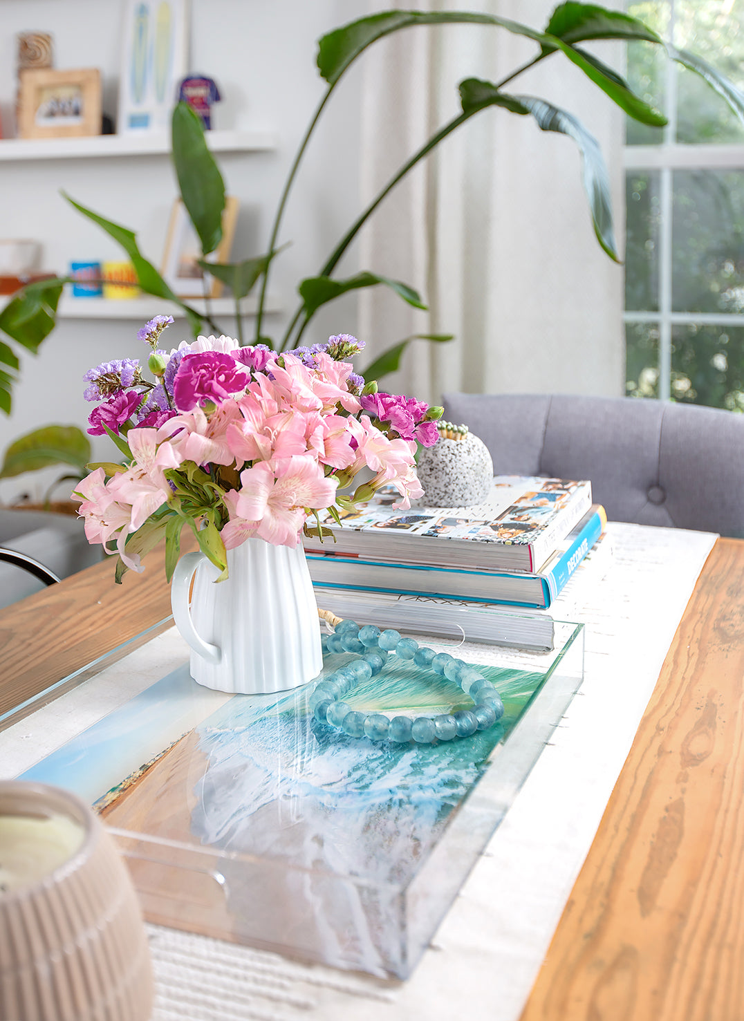 aerial ocean photograph on clear acrylic serving tray styled on dining table with flowers